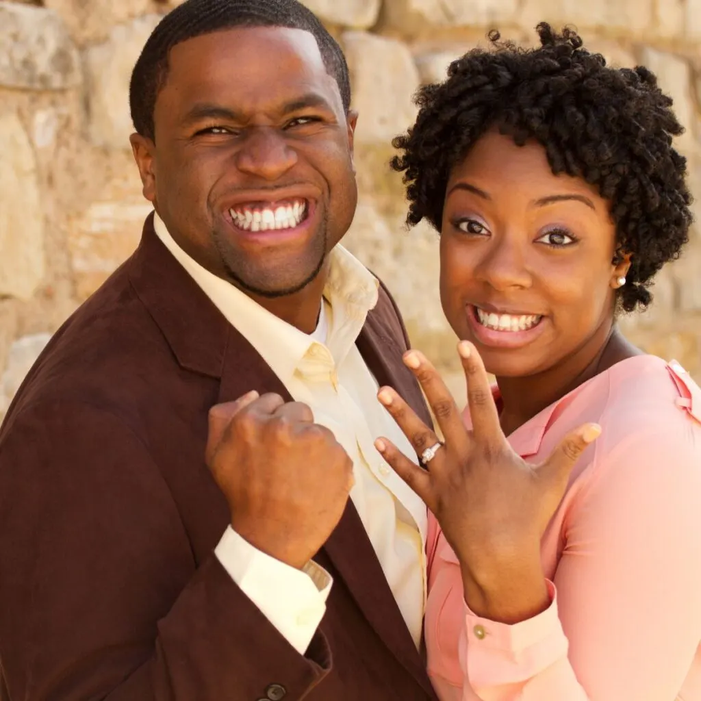 black couple showing off engagement ring excitingly