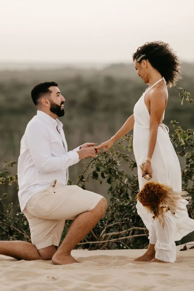 man proposing to beautiful woman on one knee.