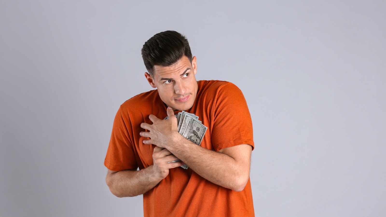 stingy man hugging money